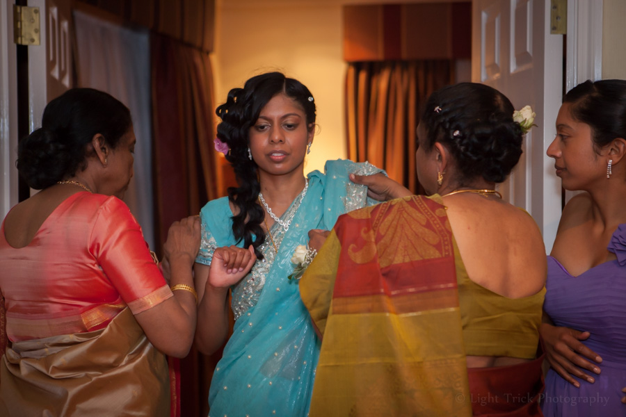 women help bride put on a sari